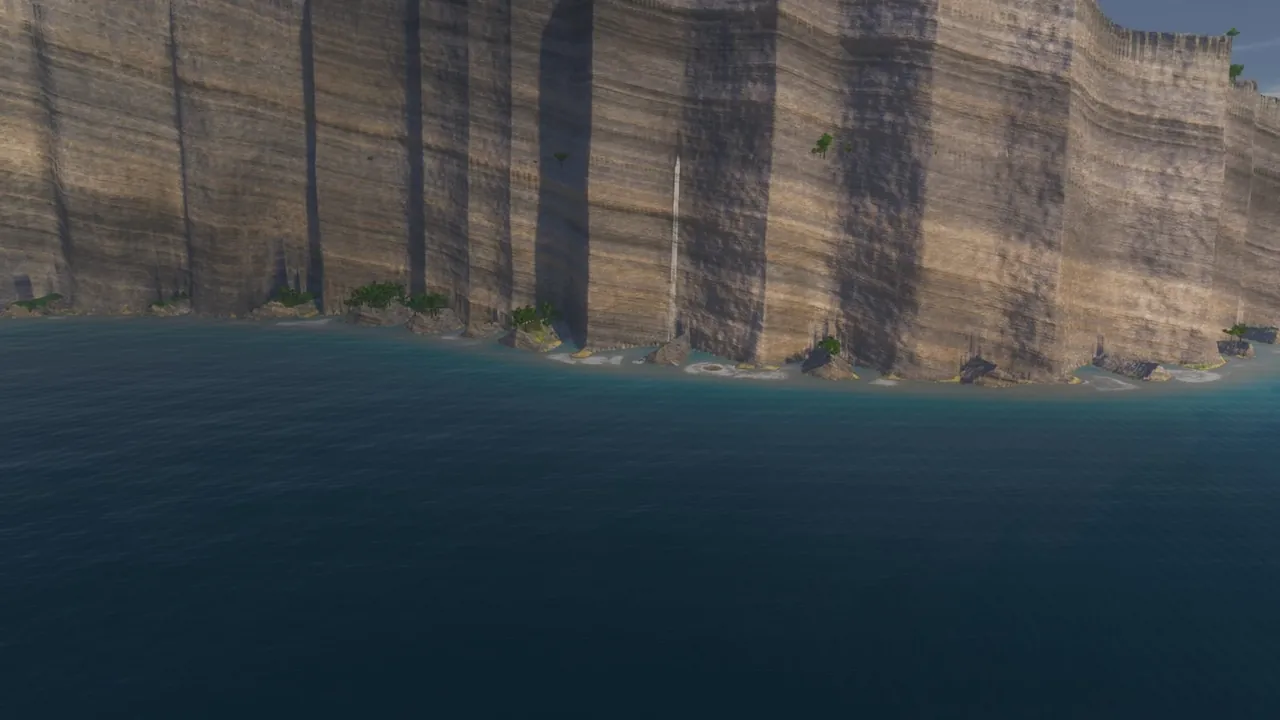 A tall banded sea cliff seen from the water, with one thin white waterfall running from its rim straight down to the sea